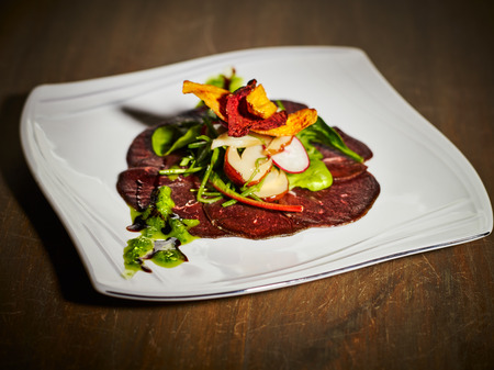 The appetizer, cold-smoked reindeer meat and the salad on the plateの写真素材