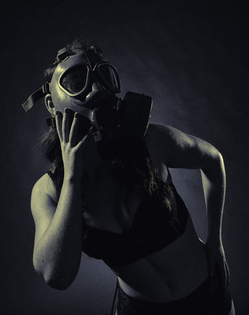 Gloomy atmosphere, sexy woman wearing a gas mask and lingerie - split toning, black and white image, intentional film grain addedの写真素材