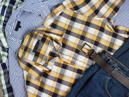 Close up, men's casual patterned shirts and jeans in the same stackの写真素材