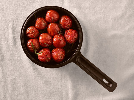 Grilled cherry tomatoes in a small cast iron pot, rosemaryの写真素材