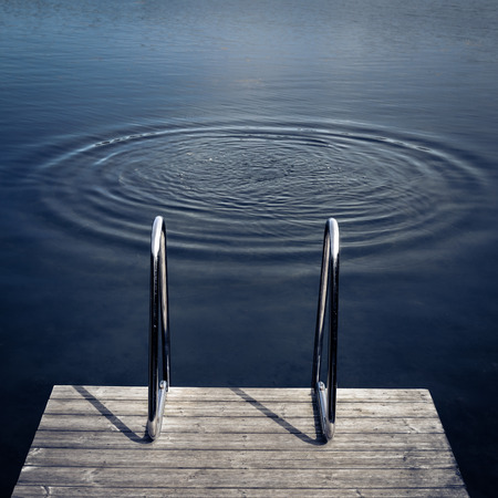 Swimming dock and a ladder, water ripples, drowning scene.の写真素材