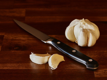 Garlic and knife on the wooden cutting board, horizon imageの写真素材