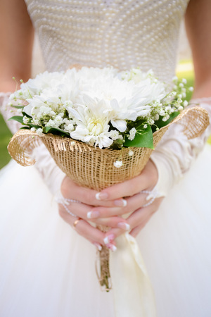 Wedding bouquet on the background of the bride in a white dressの写真素材