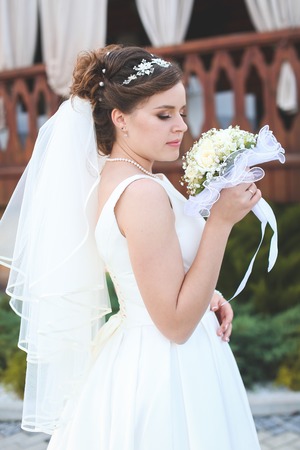 beautiful bride in a white lush dress walks outdoorsの写真素材