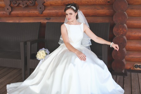 beautiful bride in a white lush dress walks outdoorsの写真素材