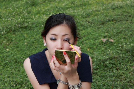 Beautiful woman applying colorful eye makeupの写真素材