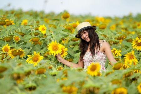 portrait of a happy young girl in a sunflower fieldの写真素材