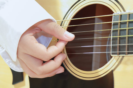 Close-up of a guitar and playing hands