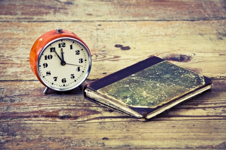 Time to read, old alarm and book on old wood floorの写真素材