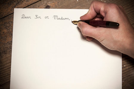 Old fashioned letter with a pen in a hand