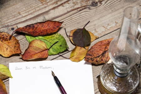 Old fashioned letter with a pen and leafsの写真素材