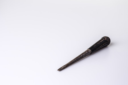 Old rusty black screwdriver on white の写真素材