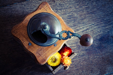 Vintage wooden coffee mill grinder with yellow flowers in open drawer - on the wooden table