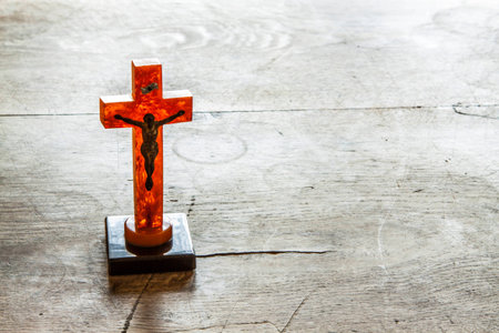 Beautiful old cross with jesus on the old wooden floor