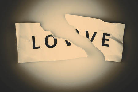 "Love" word written on torn paper on whiteの写真素材