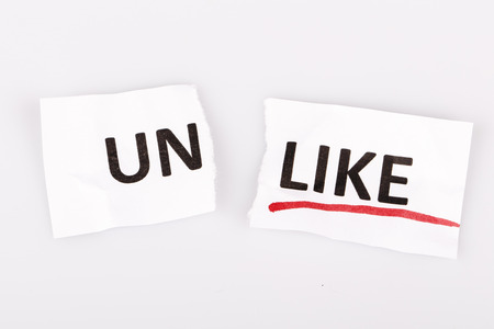 The word unlike changed to like on torn paper and white backgroundの写真素材