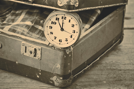 Old suitcase with old alarm clock and old shirtの写真素材
