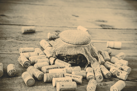 cork from wine bottle and glass of jam on the wood floorの写真素材