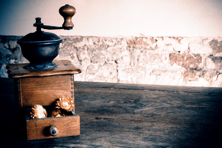 Vintage wooden coffee mill grinder with yellow flowers in open drawer - on the wooden tableの写真素材
