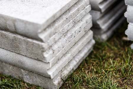 stack of grey concrete curbs on the grassの写真素材