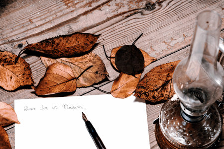 Old fashioned letter with a pen and leafsの写真素材
