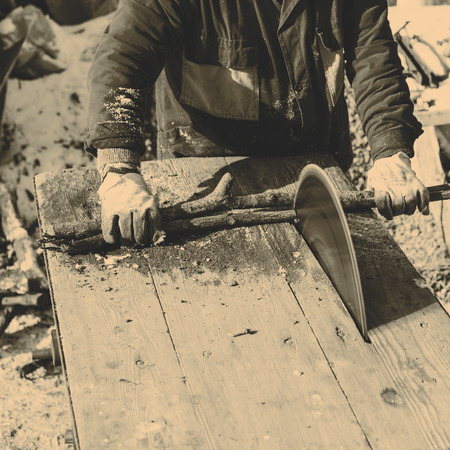 Man working with old handmade circular saw bladeの写真素材