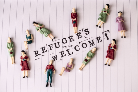 refugees welcome text on white line paper with woman figures aroundの写真素材