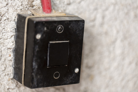 old used black light switch on white wallの写真素材