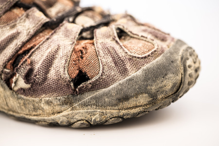 detail of old damaged hike shoe on white backgroundの写真素材