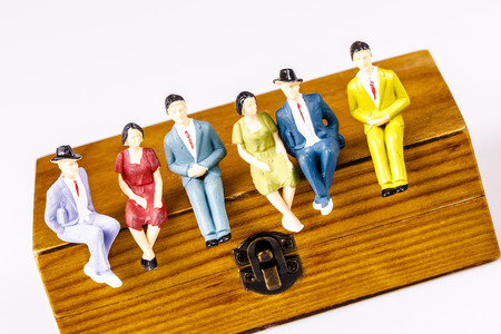 toy models of people sitting on the wooden box on whiteの写真素材