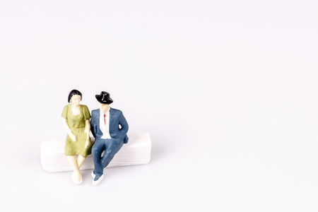 toy models of old couple sitting on chalk sofa on whiteの写真素材