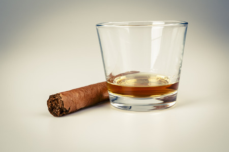 expensive drink of whisky or rum with cigar on white. gentleman relax conceptの写真素材
