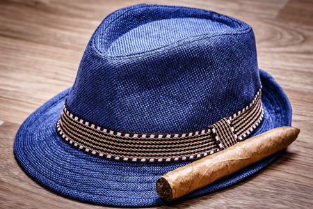 blue hat and cigar on wooden floor, smoke relax conceptの写真素材