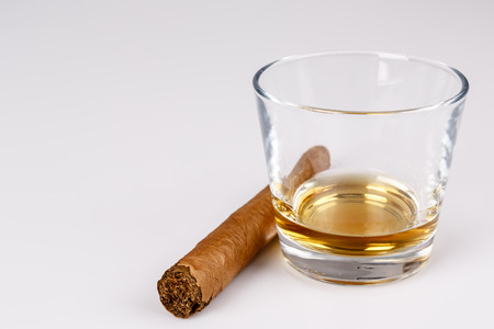 expensive drink of whisky or rum with cigar on white. gentleman relax conceptの写真素材