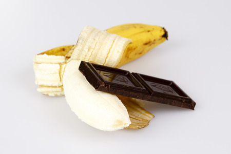 opened banana and chocolate on whiteの写真素材