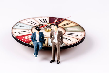 model of man sitting on beautiful old clock on whiteの写真素材