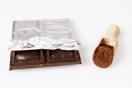 old wooden spoon with coacoa or cacao and dark chocolate on whiteの写真素材