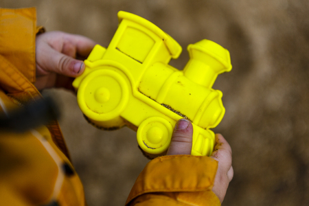 yellow locomotive sand form in boys hands, playgroundの写真素材
