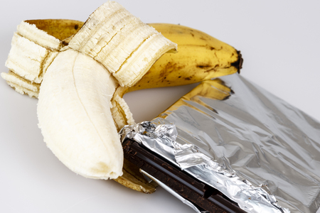 opened banana and chocolate on whiteの写真素材