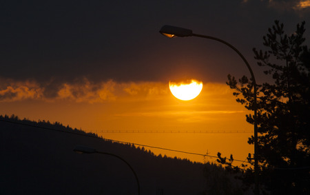 Dramatic sky with sun and cloudsの写真素材