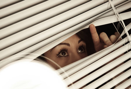 Asian airl looking through the blinds