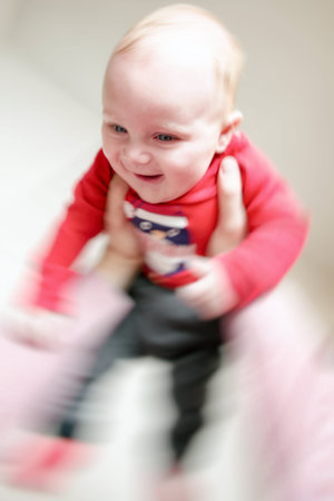 Smiling baby in hands of father