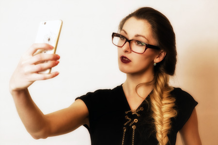 Pretty face young girl in glasses making selfieの写真素材
