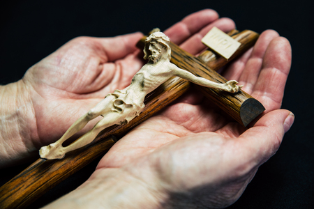 Jesus on cross in hands of seniorの写真素材