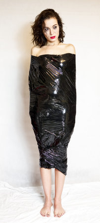 Pretty girl wrapped in black foil. Hard depressionの写真素材