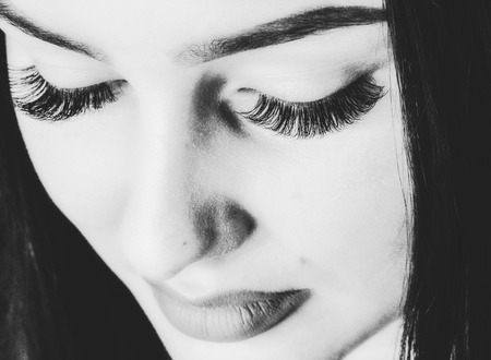 Artificial eyelashes extension. Pretty face woman with full lips. Black and white photoの写真素材