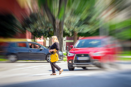 RUZOMBEROK, SLOVAKIA - AUGUST 10: Woman crossing a road on crosswalk on August 10, 2017 in...