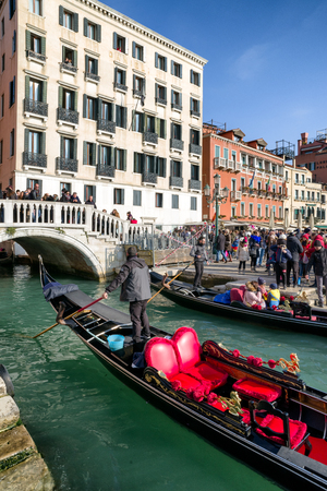 VENICE, ITALY - FEBRUARY 11: Gondolier in gondole at water canal on February 11, 2018 in Veniceのeditorial素材
