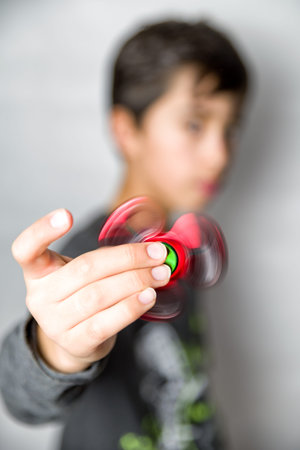 Boy with red fidget spinner in handの写真素材
