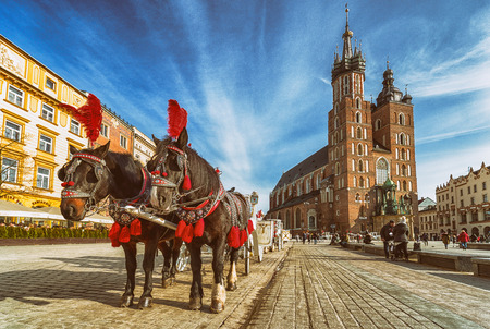 KRAKOW, POLAND - FEBRUARY 19: Horse carriage at Main square and St. Mary's Basilica on February 19, 2018 in Krakowのeditorial素材